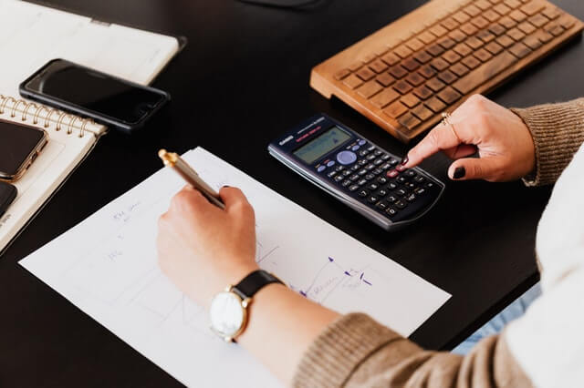 Our Top Selling Products crop woman using calculator and taking notes on paper